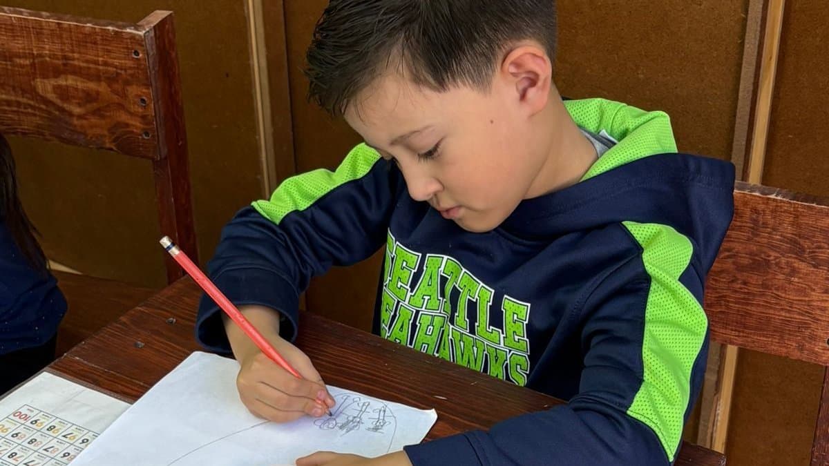 Edier trabajando en su pupitre en el Colegio San Isidro